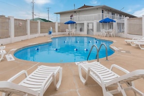 A swimming pool with white lounge chairs and blue umbrellas, surrounded by a white fence with a 'NO DIVING' sign. - 1 King Bed Mob Acc Tub Nsmk Micfridg (Remote City USA)