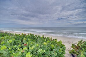 A beach with a view of the ocean and overcast sky. - Oceanfront Gem! Steps to Sand, Miles from Ordinary (Vero Beach)