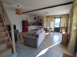 A modern kitchen with a dining area, a sofa, and a staircase. - The Charming Sicarderie Guesthouse, 30 minutes from Bordeaux (Peujard)