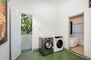 A laundry room with a washing machine, a dryer, and a toilet. - Laoxao Memories (Đà Nẵng)