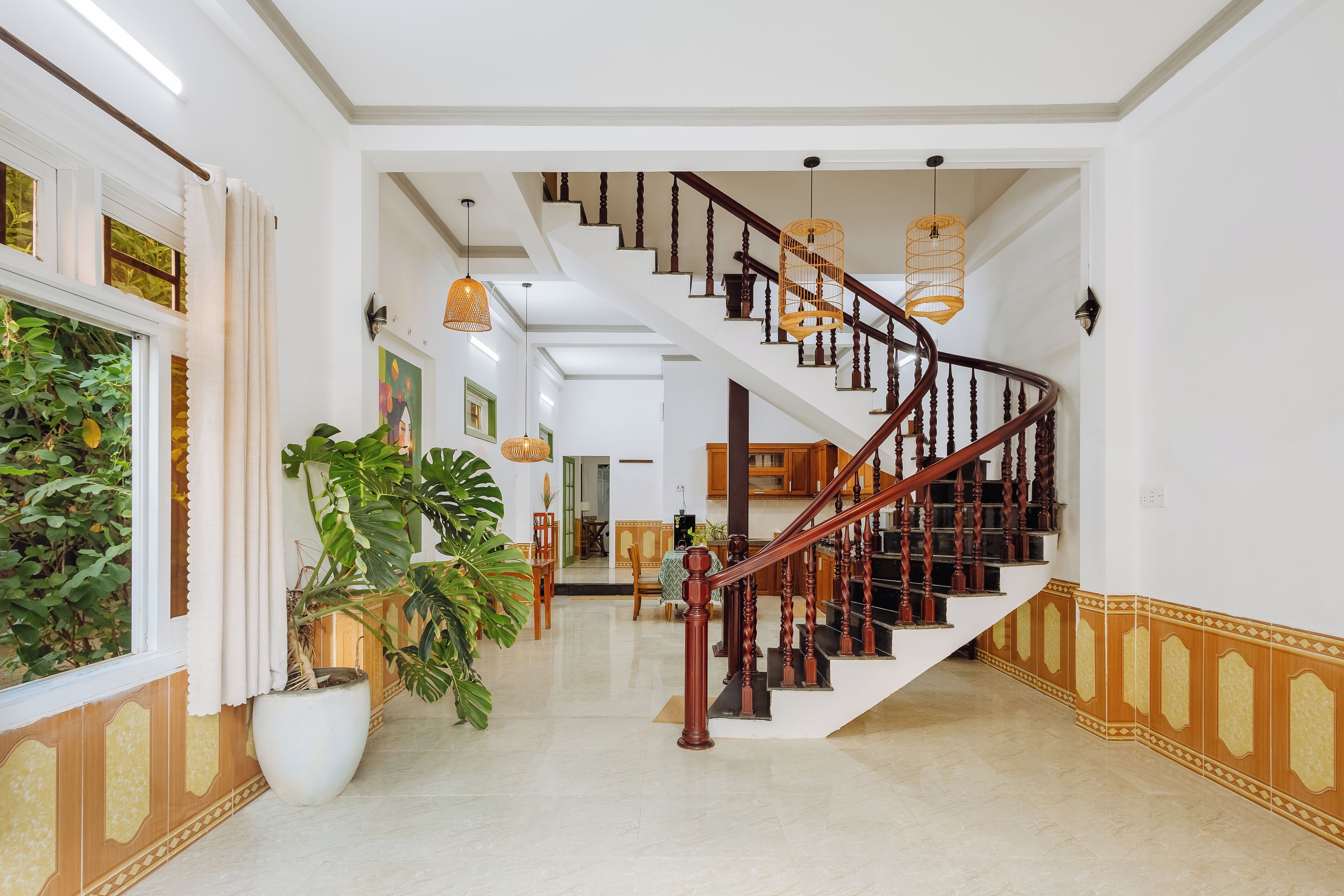 A spacious interior with a grand staircase, a dining area, and a view of the outdoors.