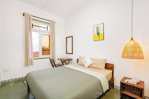 A bedroom with a bed, a small table, a chair, a hanging lamp, and a window with curtains. - Laoxao Memories (Đà Nẵng)