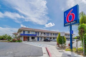 Ein Motel mit blauem Schild, das kostenloses WLAN, einen barrierefreien Eingang und einen Parkplatz anzeigt.