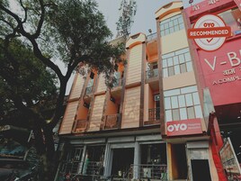 Un edificio de varios pisos con balcones, un letrero destacado que dice 'OYO Recommended' y un escaparate visible con señalización en un idioma extranjero.