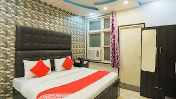 Un dormitorio con cama, armario, ventana con cortina y pared estampada.