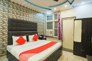 Un dormitorio con cama, armario, ventana con cortina y pared estampada.