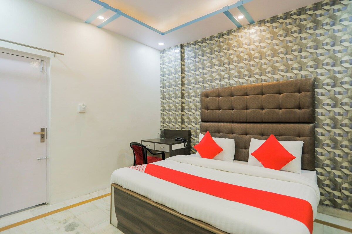 A bedroom with a bed, a desk, and a chair.