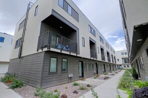 A multi-story residential building with balconies, a covered outdoor area, and a landscaped garden. - Leos Cozy Getaway near SLC Airport & Downtown (Salt Lake City)