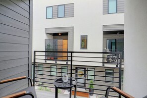 A balcony with a glass table, chairs, and a potted plant. - Leos Cozy Getaway near SLC Airport & Downtown (Salt Lake City)