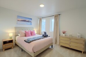 A bedroom with a bed, bedside tables, a dresser, a painting, and a window with curtains. - Leo’s Cozy Getaway near SLC Airport & Downtown (Salt Lake City)