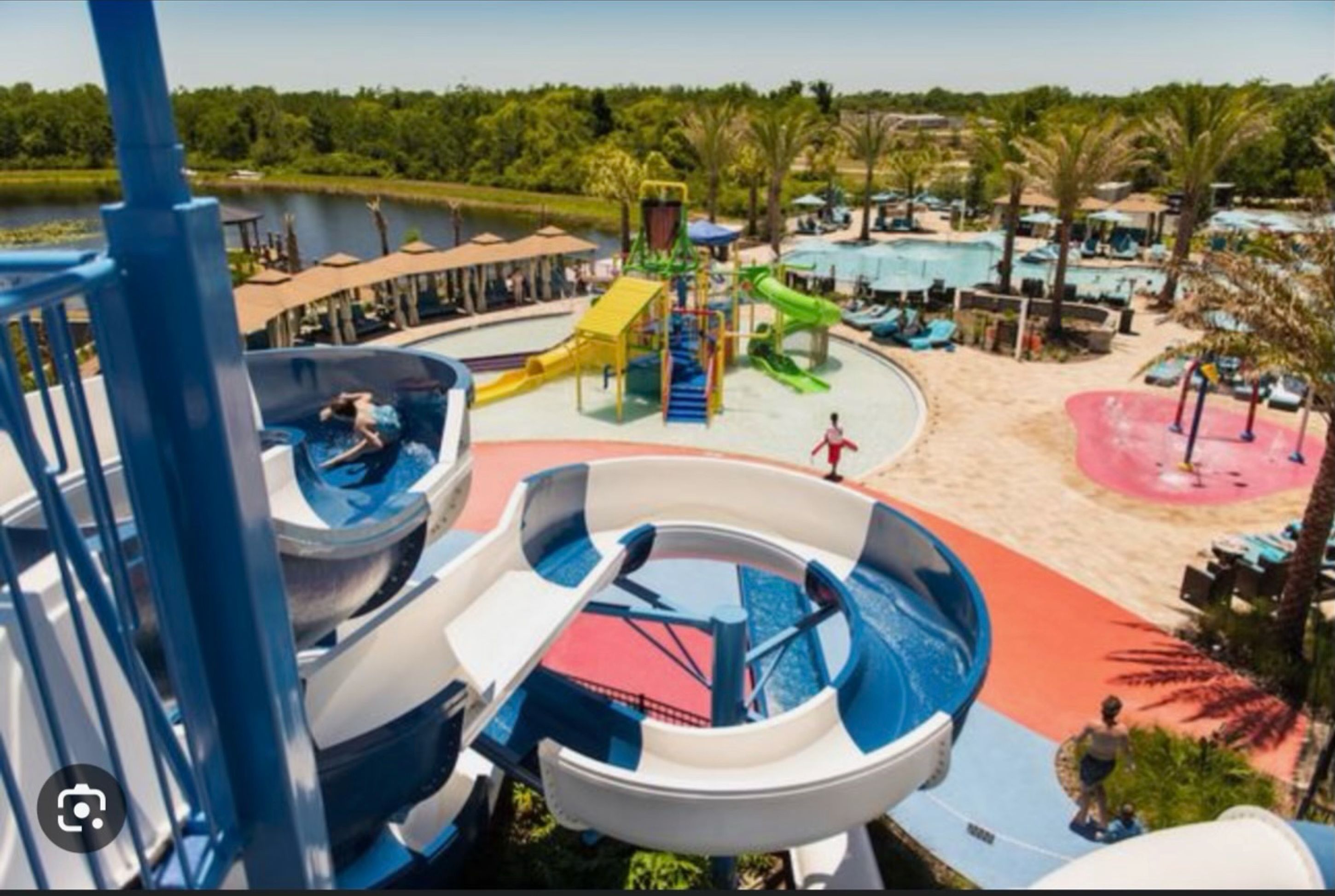 A water park with multiple slides and a sandy play area.