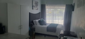 A bedroom with a bed, a desk, and a wardrobe. - Avondrust Self Catering Studio Aandrus (eManzimtoti)