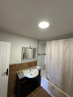 A bathroom with a sink, mirror, and shower curtain. - Apartment 'Ventisca' with Mountain View (Monachil)