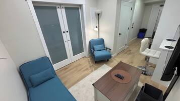 Una sala de estar moderna con un sofá, una mesa de centro y un sillón azul.