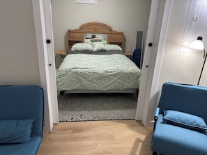 Une chambre à coucher avec un lit, une table de chevet, une lampe et une chaise.