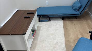 A room with a wooden table, a blue sofa, and a white cabinet.