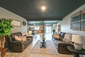 Ein geräumiger Wohnbereich mit zwei Sofas, einem Couchtisch und einer großen Pflanze.