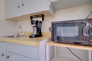 A kitchenette with a coffee maker, a microwave, a sink, and a cabinet. - Waterfront Lake Huron Condo at Sunrise Side Resort (Greenbush)