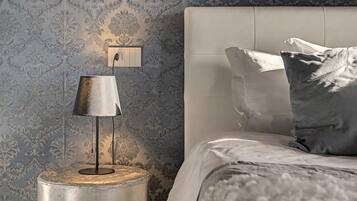 Une chambre à coucher avec un lit, une table de chevet avec une lampe et un mur recouvert d’un papier peint à motifs.
