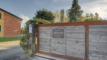 En port ind til en ejendom med et skilt, der angiver 'BED & BREAKFAST' og kontaktoplysninger.