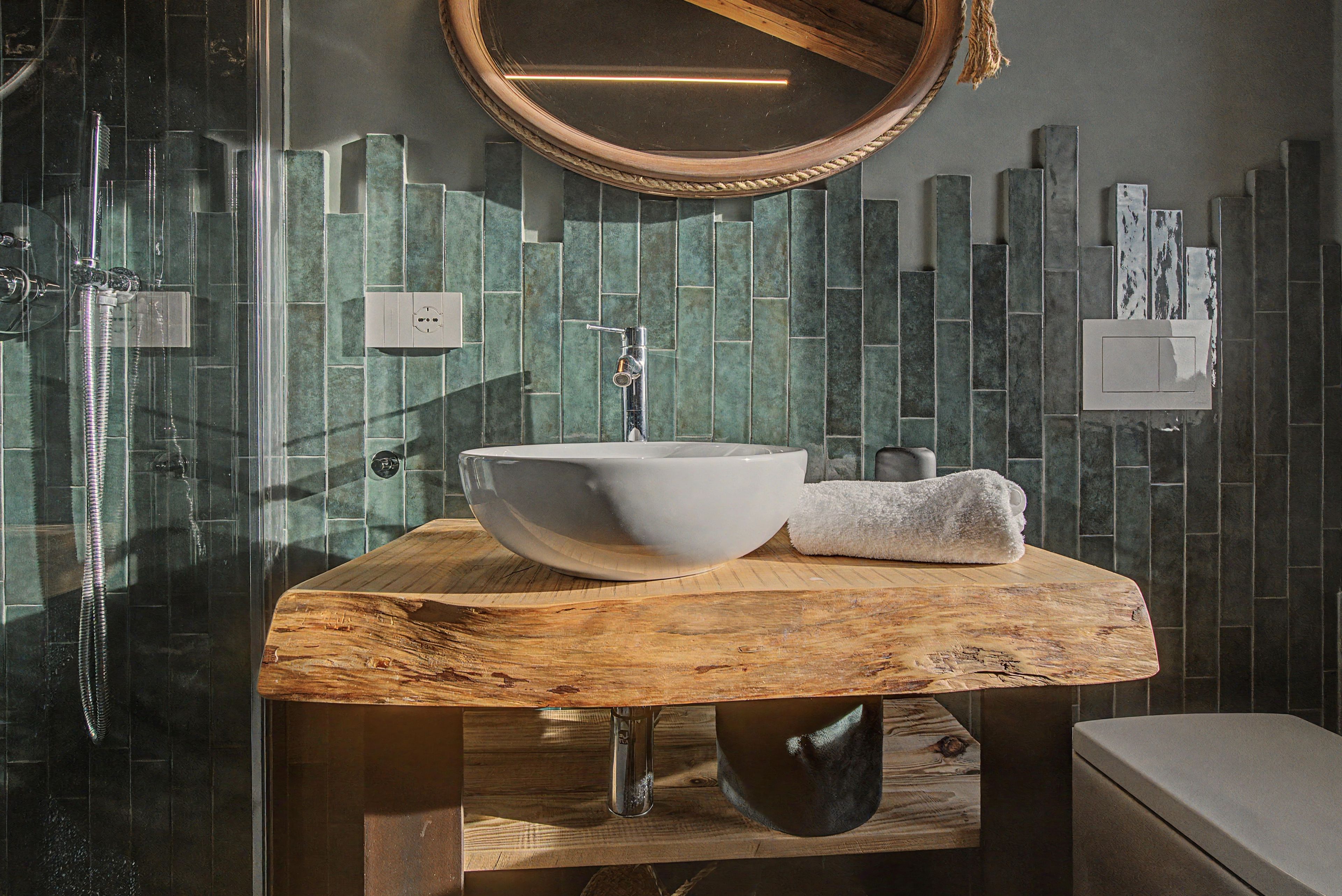 Un bagno con un mobile bagno in legno, un lavabo bianco, un asciugamano e uno specchio.