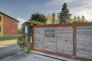 A gated entrance to a property with a sign indicating 'BED & BREAKFAST' and contact information.