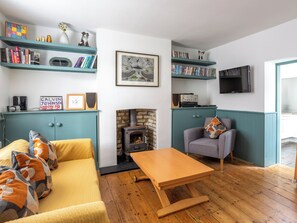 A cozy living room with a fireplace, a sofa, a coffee table, and a television. - Old Anchor Cottage - UK51953 (Broadstairs)