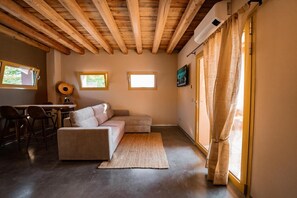 A cozy room with a wooden ceiling, a sofa, a small table, and a TV. - Room 'Gioia Di - King Superior' with shared garden, Wi-Fi and air conditioning (Biverone)