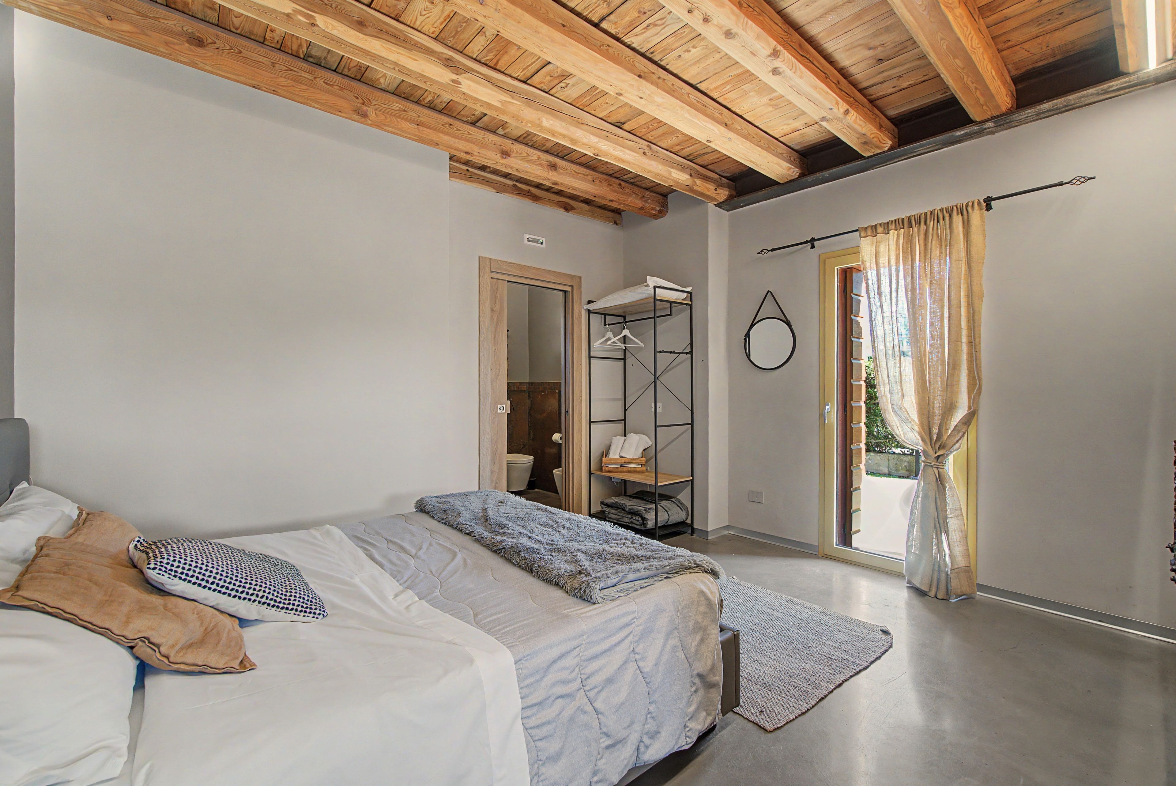 Une chambre avec un lit superposé, une armoire, une salle de bain et une vue par la fenêtre.