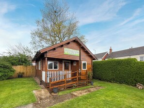 A wooden cabin with a porch and a sign that reads 'Luxury Log Cabins For Hire'. - Log Cabin One - UK51959 (Sutton-on-Sea)