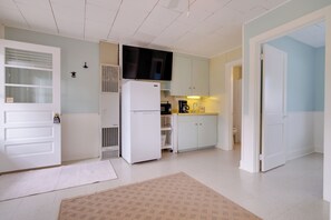 A compact kitchen with a refrigerator, microwave, and a coffee maker.