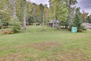 A house with a porch, surrounded by a grassy yard and trees. - Fish the Right Fork River: Tallmansville Home (Tallmansville)
