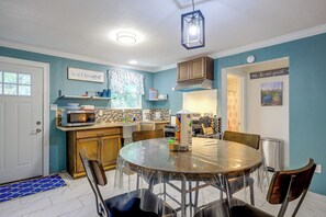 A kitchen with a round table, chairs, a microwave, and a cabinet. - On-Site Trails & Wildlife! Hill Country Escape (Utopia)