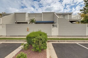 A building with a flat roof, a covered walkway, and a small green bush in the foreground. - Walk to Beach & Northside Park! Monthly Stay Condo (Ocean City)