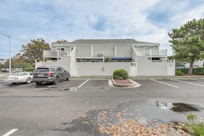 A two-story building with a parking lot in front. - Walk to Beach & Northside Park! Monthly Stay Condo (Ocean City)