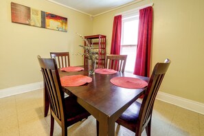 A dining room with a wooden table, six chairs, and red placemats. - Walk to Rosamond Gifford Zoo & Dining! Cozy Unit (Syracuse)