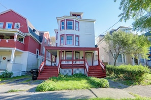 A two-story house with a front porch, a red staircase, and a white upper level. - Walk to Rosamond Gifford Zoo & Dining! Cozy Unit (Syracuse)