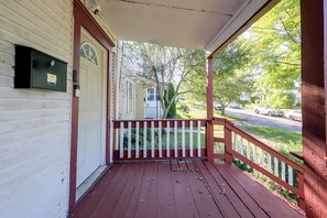 A wooden porch with a red railing, a mailbox, and a view of a street with cars and trees. - Walk to Rosamond Gifford Zoo & Dining! Cozy Unit (Syracuse)