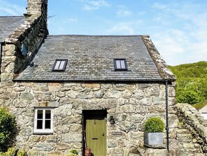 A stone building with a green door, a small window, and a sign reading 'MEN STADL'. - Hen Stabal - UK51984 (Llanfair, near Harlech)