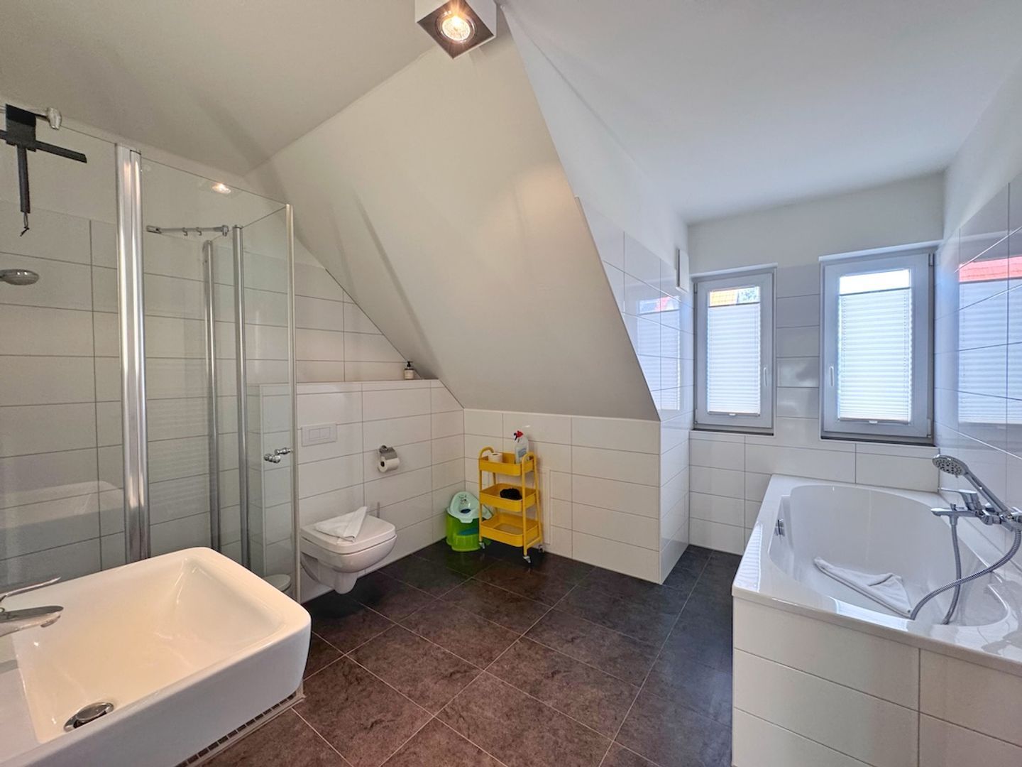 A modern bathroom with a shower, toilet, and bathtub.