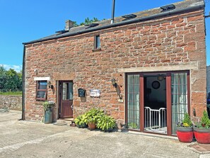 A stone building with a wooden door, a window, and a sign that reads 'Another Dawn.' - Another Dawn - UK52026 (Wigton)