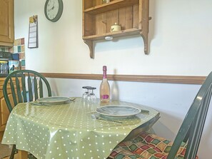 A dining table with a polka dot tablecloth, two chairs, and a bottle of champagne. - Another Dawn - UK52026 (Wigton)