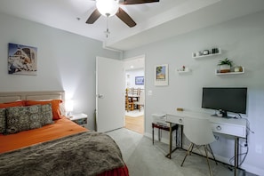 A bedroom with a bed, a desk, a chair, a television, and a ceiling fan. - Viva La Dolce Vita in the Heart of Little Italy! (San Diego)