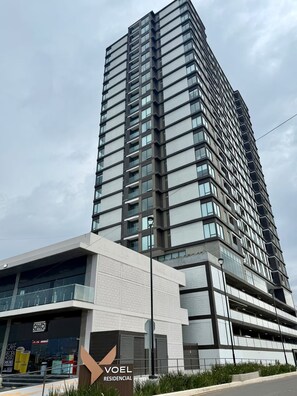 Un edificio residenziale a grattacielo con numerosi balconi e un design moderno.
