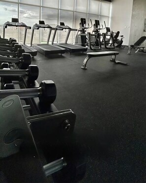 A gym with treadmills, weight machines, and dumbbells. - Vrbo Property (Saltillo)