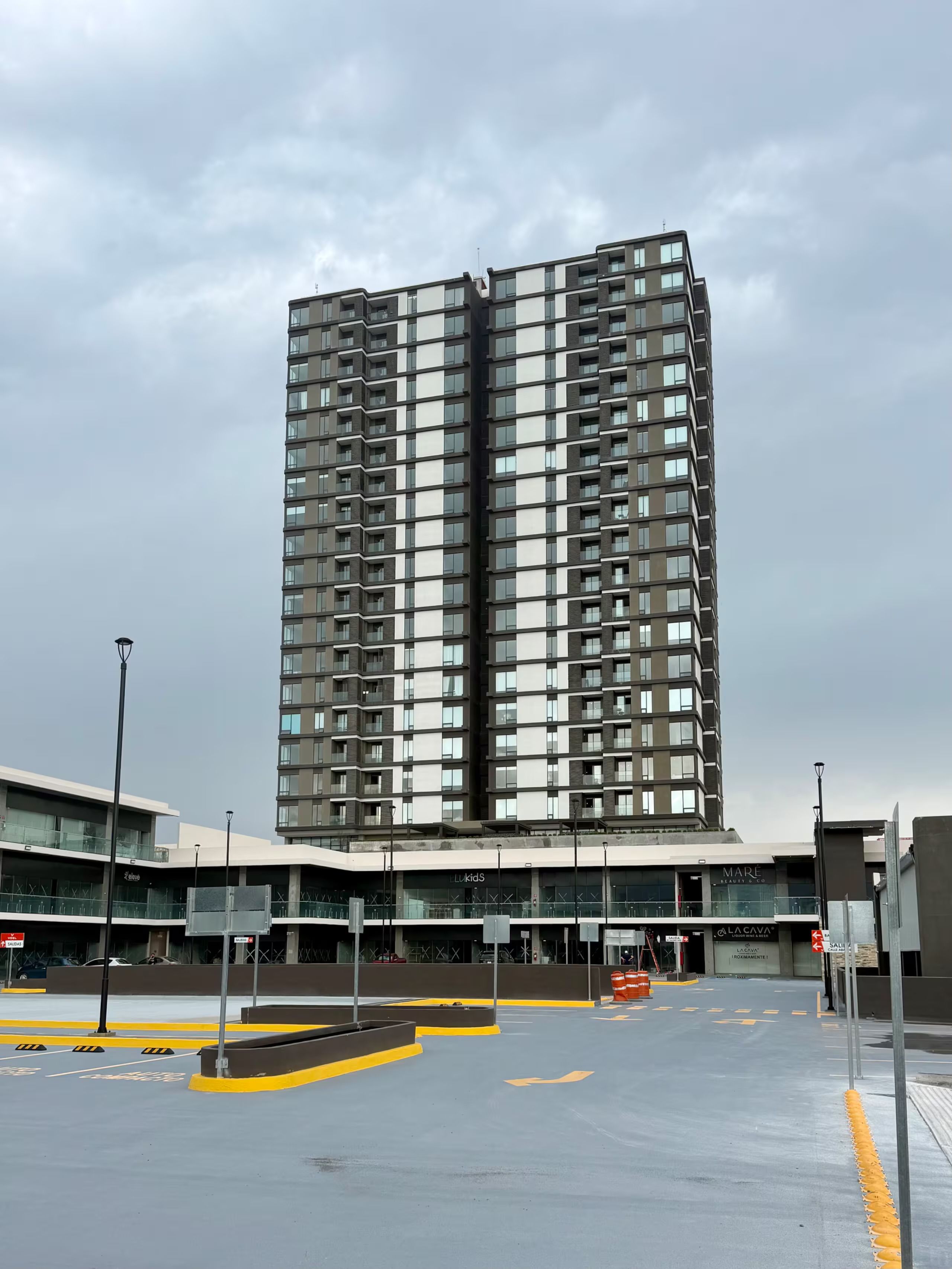 A multi-story building with a modern architectural design, featuring a series of balconies and large windows.