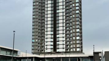 A multi-story building with a modern architectural design, featuring a series of balconies and large windows.