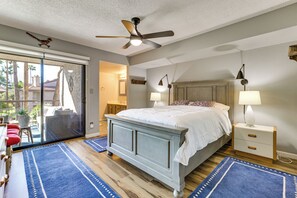 A bedroom with a bed, two bedside tables, a ceiling fan, and a view through a sliding glass door. - Pool & Spa! Stylish 2nd-Floor Scottsdale Retreat (Scottsdale)