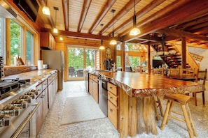 A spacious kitchen with a large island, wooden cabinetry, and a stone-tiled floor. - Game Room, Hot Tub! Retreat 3 Mi to Holiday Valley (Ellicottville)