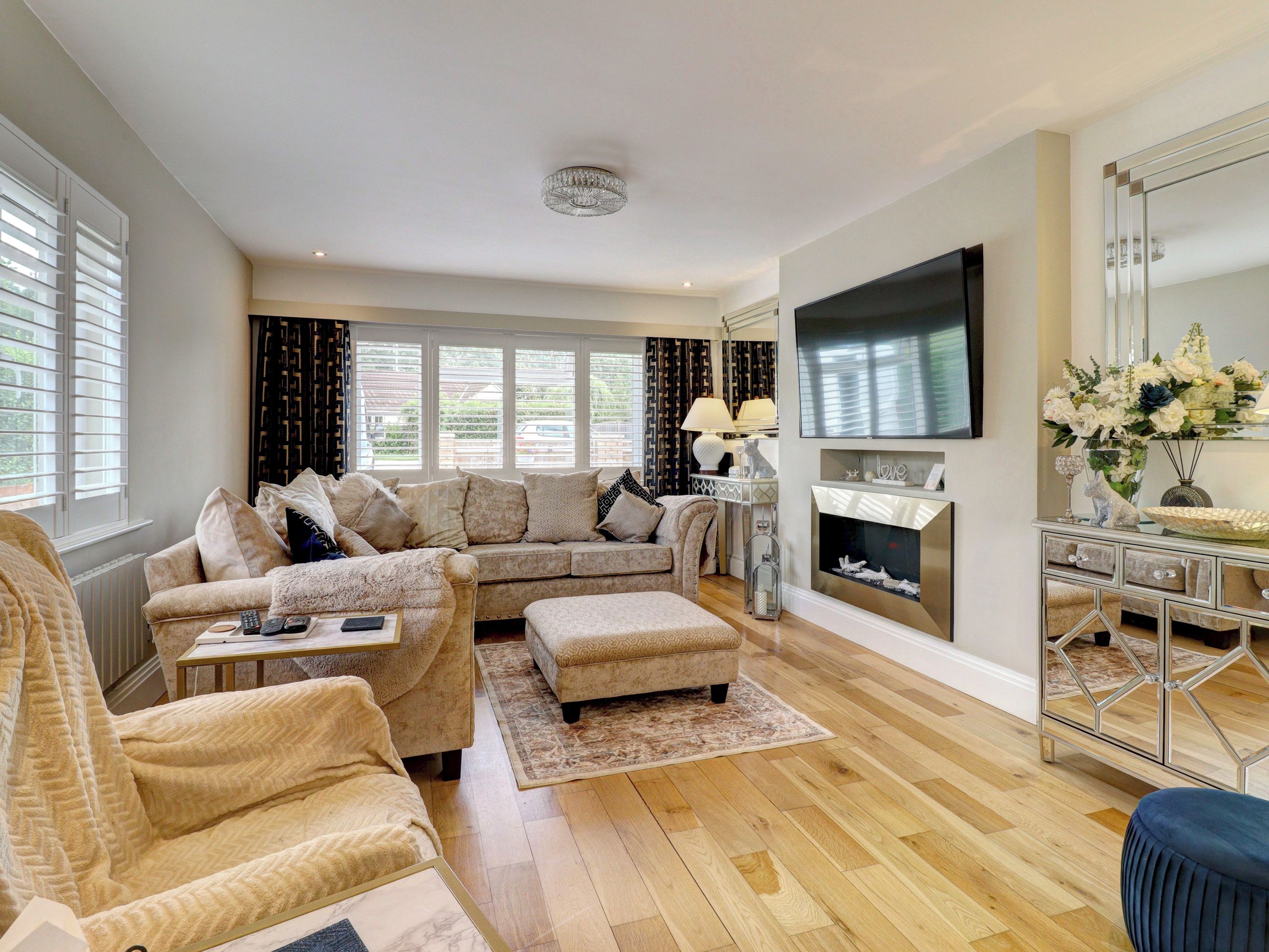 A living room with a sectional sofa, ottoman, and a fireplace.